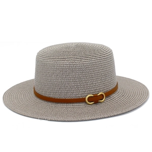 Détail d'un chapeau de paille canotier avec ruban en cuir marron et boucle dorée