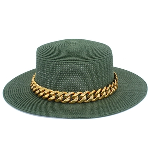 Gros plan d'un chapeau de paille vert foncé orné d'une chaîne dorée élégante et moderne