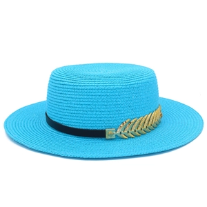 Detail of woven straw fedora featuring a black band and golden feather ornament