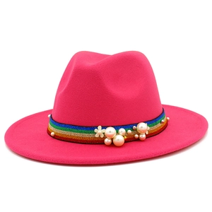 Detail of fuchsia wool fedora with rainbow striped band, white pearls, and flower accent