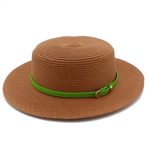Detailed view of woven boater hat featuring a vibrant green leather buckle strap detail