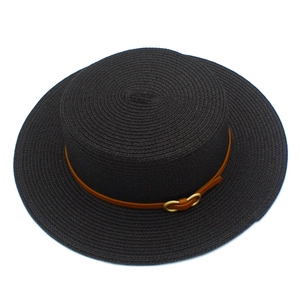 Détail du chapeau de paille noir avec tissage fin et ruban en cuir marron à boucle dorée