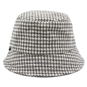 Close-up of the thick houndstooth fabric texture and black label on the bucket hat