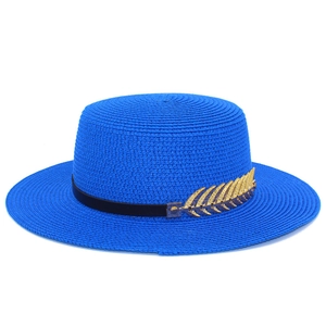 Detailed macro view of bright blue boater hat with black ribbon and gold feather ornament