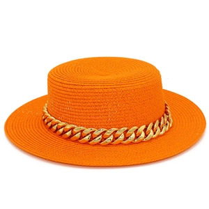 Détail du tissage du chapeau de paille orange vif et de l'élégante chaîne dorée décorative