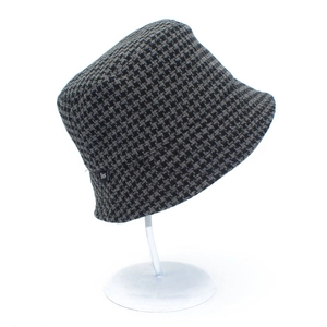 Close-up of houndstooth bucket hat with black 'Yes' label and thick knitted texture