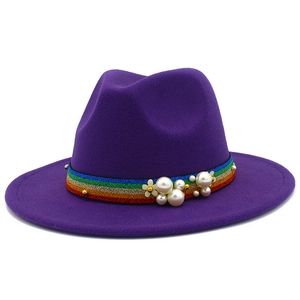 Close-up of purple wool fedora hat featuring rainbow striped ribbon and pearl accents