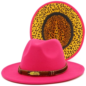 Detail of magenta wide brim fedora showing leopard print lining and golden feather buckle