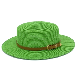 Detail of green straw sun hat featuring a brown leather band and golden metal buckle