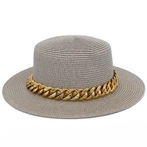 Détail d'un chapeau de paille gris avec large bord plat et chaîne dorée décorative