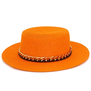 Détail d'un chapeau de paille orange avec texture tissée et bande décorative chaîne dorée