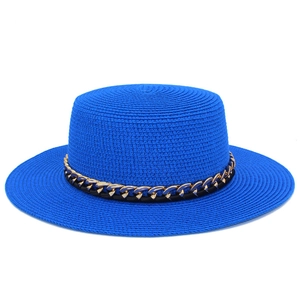 Détail du chapeau de paille bleu marine avec chaîne dorée et ruban noir tressé
