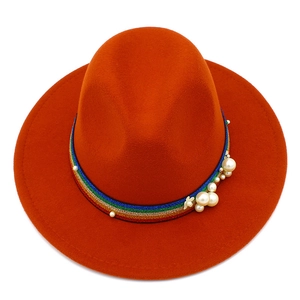 Detail of orange wool fedora featuring a rainbow ribbon with pearls and flower accents