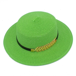Close-up of bright green flat-top straw hat with black band and gold leaf ornament