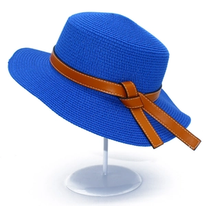Detail of blue straw sun hat with brown leather band and white contrast stitching
