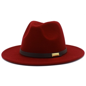 Macro detail of wine red felt fedora hat with elegant golden buckle on decorative band