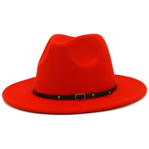 Détail d'un chapeau fedora en laine rouge avec ruban en cuir noir et boucle dorée