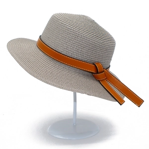 Detail of light beige straw sun hat with textured weave and brown leather band