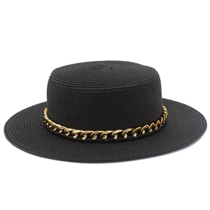 Détails de la texture du chapeau canotier noir avec une chaîne en métal doré élégante
