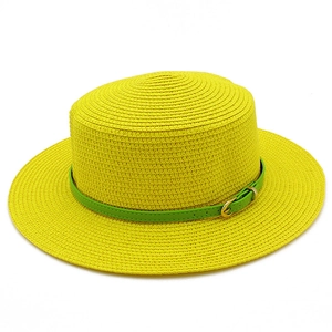 Detailed view of yellow straw hat with a narrow green leather belt and gold metal buckle