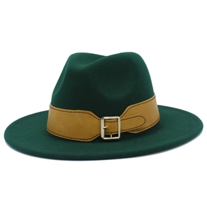 Detail of dark green fedora with premium wool texture and brown leather strap with metal buckle