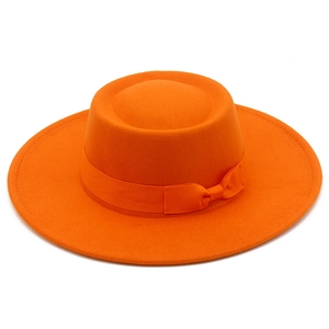 Detail eines orangefarbenen Wollfilzhuts mit flacher Krempe und passender Bandschleife
