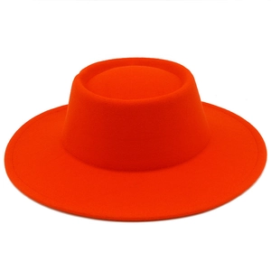 Détail d'un chapeau en laine orange à bord large avec calotte plate et coutures fines