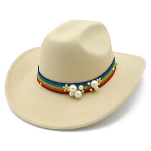 Detail of bohemian rainbow ribbon with pearls and flower charms on a beige wool fedora