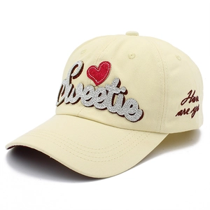 Détail de la casquette beige avec lettrage Sweetie pailleté et broderie latérale