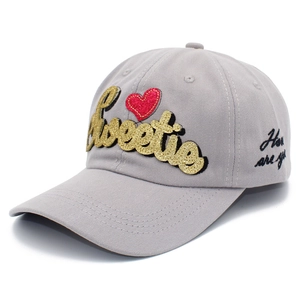 Casquette de baseball grise avec broderie Sweetie dorée et cœur rouge sur fond blanc