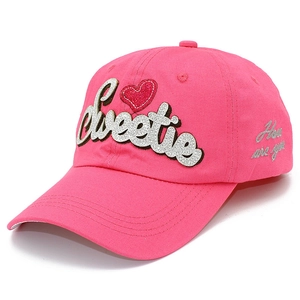 Gros plan sur la casquette rose avec broderie Sweetie et motif cœur à paillettes