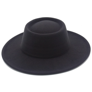 Vue détaillée du chapeau en feutre noir à bord plat montrant la texture laineuse