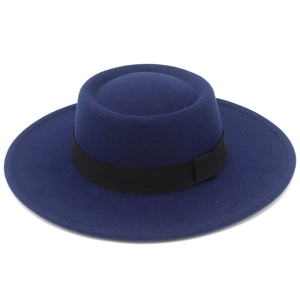Macro detail of navy blue felt boater hat with black grosgrain ribbon and wide flat brim