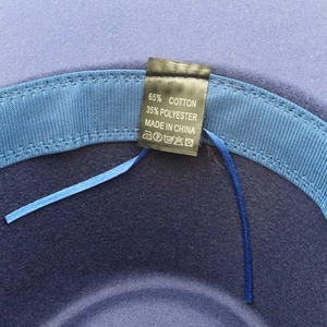 Dettaglio dell'interno del cappello in lana con laccetto regolabile ed etichetta