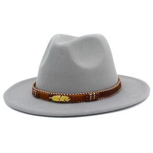 Detail of grey wool fedora hat featuring ethnic embroidery and golden feather charm