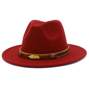 Close-up of dark red wool fedora featuring a golden feather buckle and ethnic woven band
