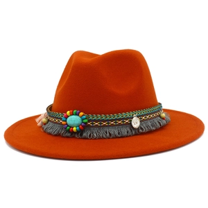 Détail d'un fedora orange avec bande perlée ethnique, pierre turquoise et franges de pièces