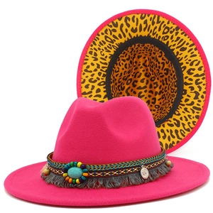 Deep pink fedora hat with ethnic band and leopard print brim detail shown on white