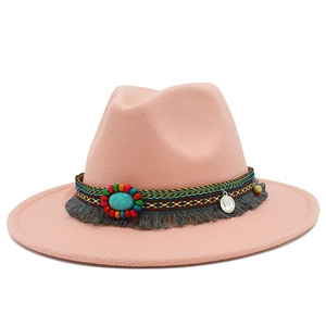 Détail de chapeau Fedora rose avec pierre turquoise, ruban tissé et pompons à franges