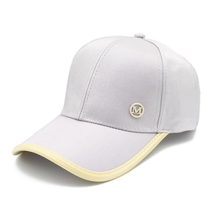 Detailed macro view of an adjustable baseball cap side with a metallic M logo emblem