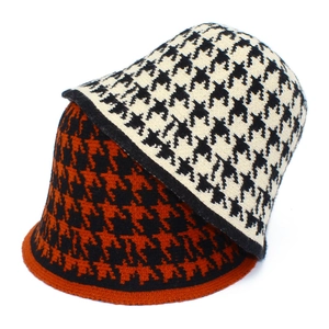 Detail of knitted bucket hats showing houndstooth patterns in black-orange and black-white