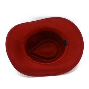 Close-up of red wool fedora hat interior showing black care label and fabric sweatband