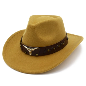 Close-up of leather hat band with metallic bull head logo on khaki cowboy fedora