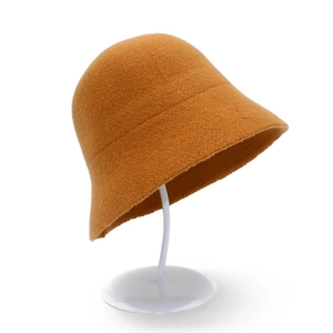 Minimalist ginger knit bucket hat for women on white stand for autumn winter warmth