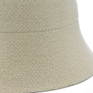 Close-up of the dense knitted wool texture on a creamy beige winter bucket hat