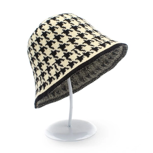 Women's knit houndstooth bucket hat in black and white winter style on white background