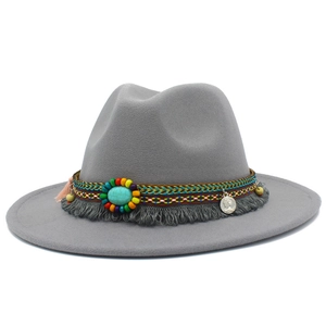 Détail du chapeau en feutre gris avec perle turquoise, pompons et ruban ethnique