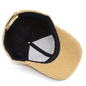 Detail of soft beige lamb wool baseball cap showing inner black lining and premium stitching