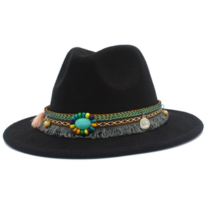 Détail d'un chapeau cowboy avec bande ethnique, pierre turquoise et glands colorés