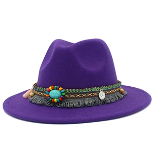 Détail d'un chapeau fedora en laine violette avec perles turquoise et pompons ethniques